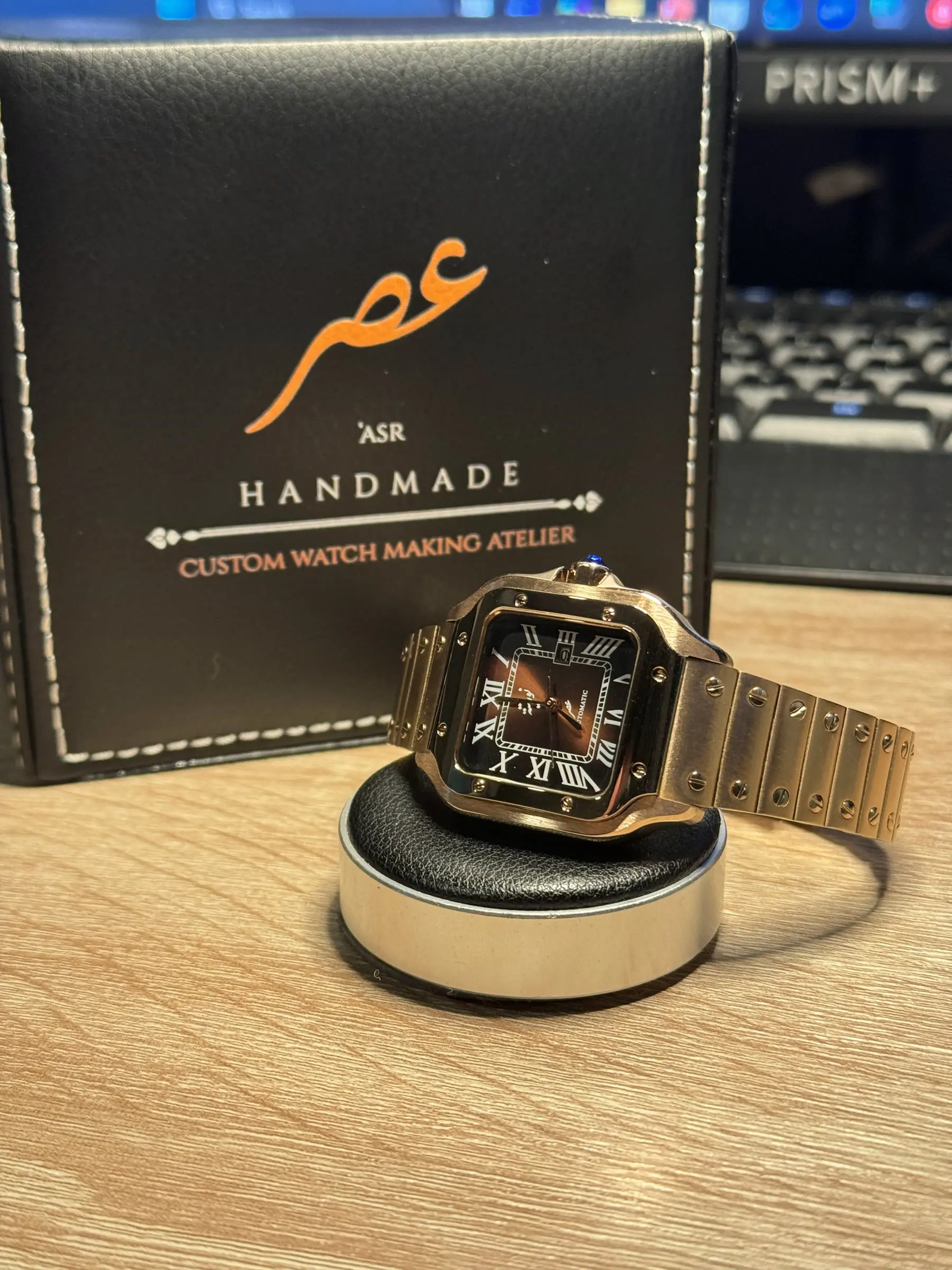 The 'ASR atelier pouch, printed with the Arabic logotype and the words Handmade, Custom Watch Making Atelier, with a finished build resting in front of it.