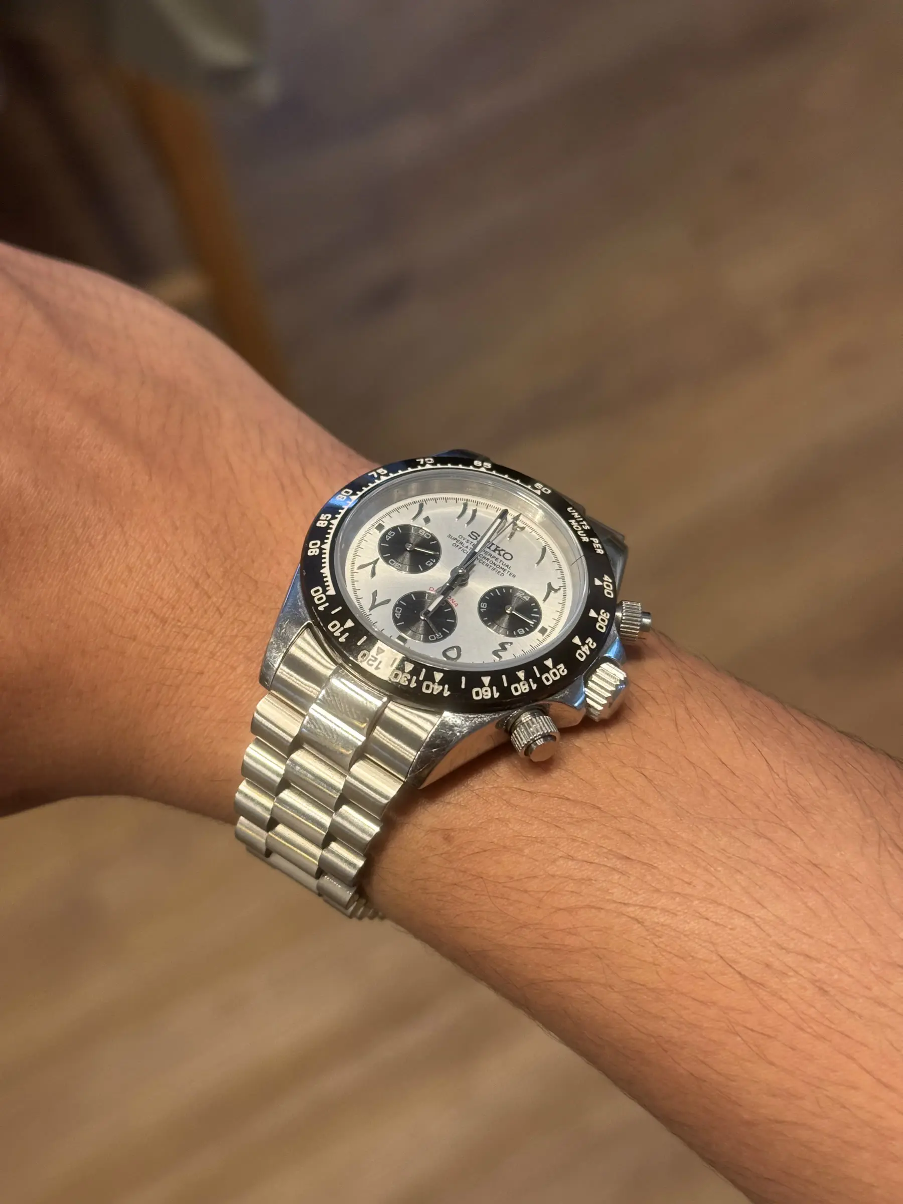 Chronograph build with a white panda dial and black sub-dials on a jubilee bracelet.