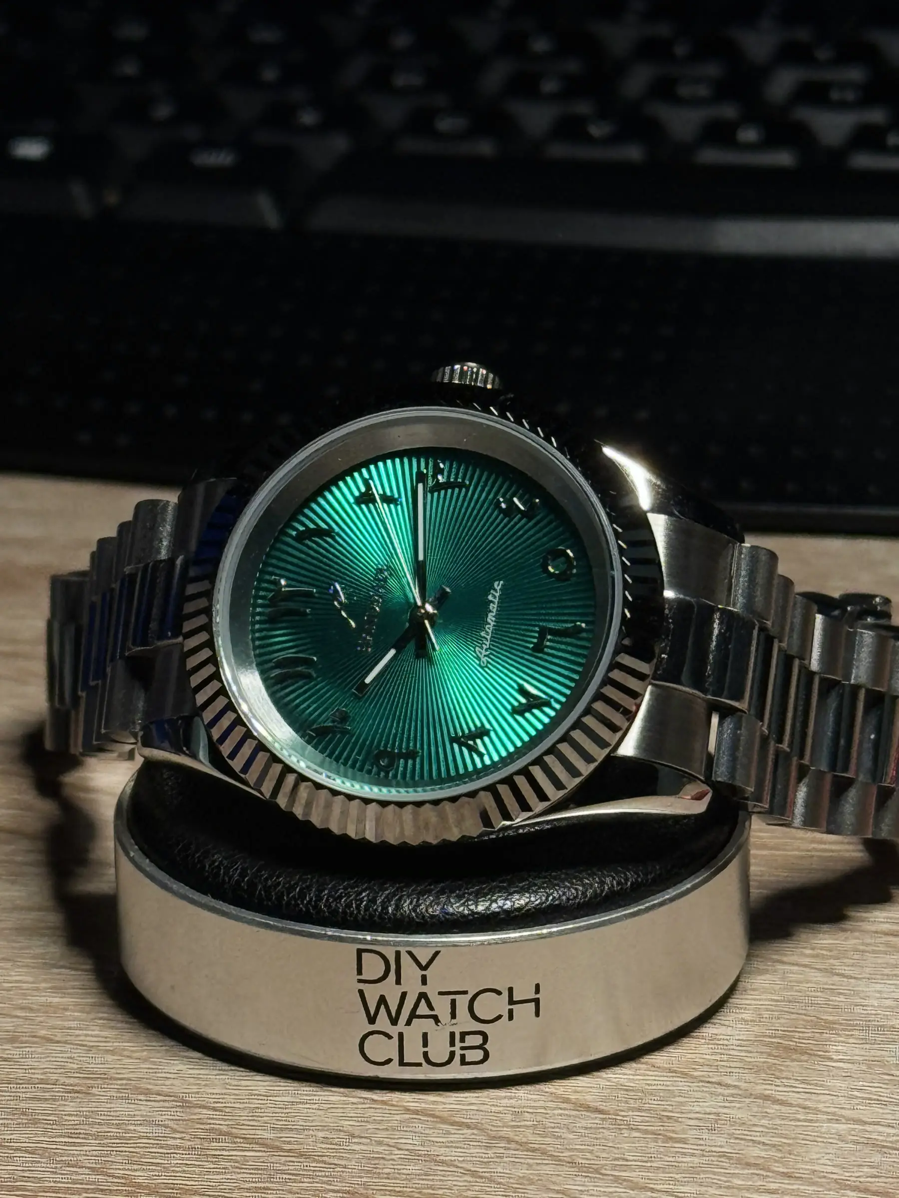 Fluted bezel build with a teal sunburst dial.