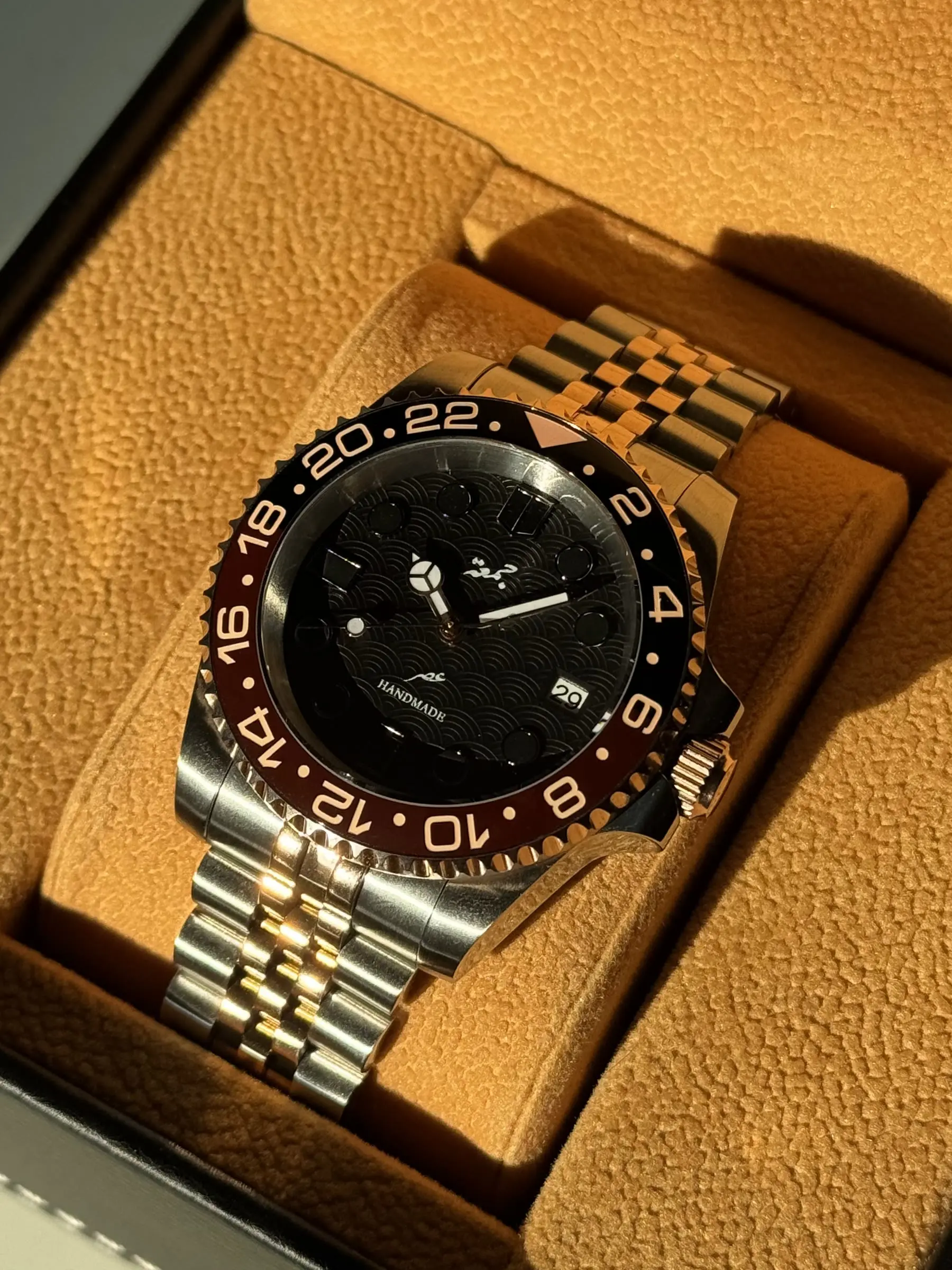 Two-tone build with a brown and black 24-hour bezel on a jubilee bracelet.