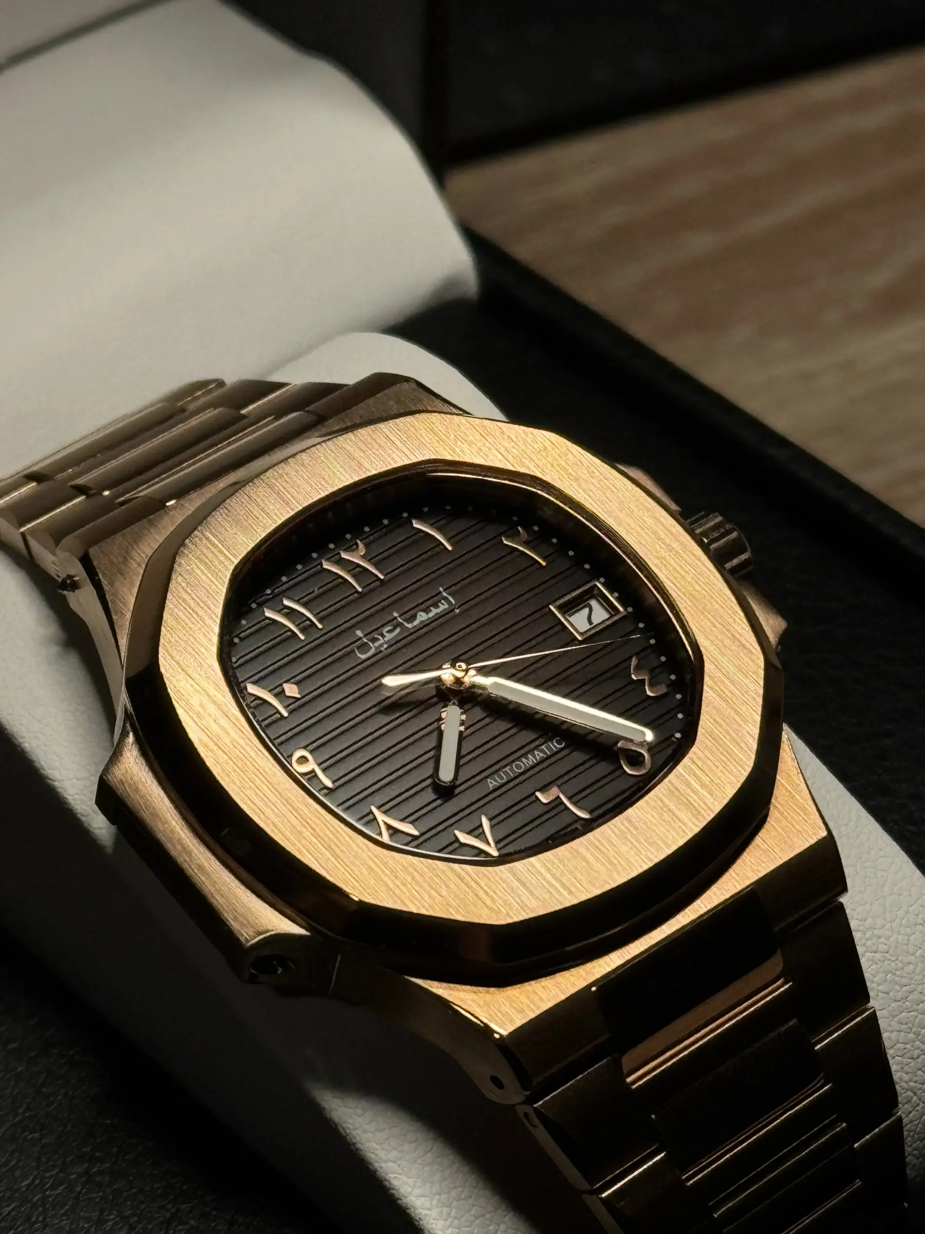 Rose gold integrated-bracelet build with a brown horizontally-embossed dial and Arabic numerals.